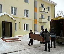 Новосёл Павел Русанов (в центре) переезжает из старого дома, где прожил 42 года, в новую трёхкомнатную квартиру